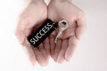 The hand carry the silver key with the label of success wording. Key to success concept isolated in white background Royalty Free Stock Photo