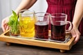 hand carrying a tray with a pitcher and glasses of beet kvass