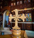 Hand carved church wooden cross with altar blurred background.