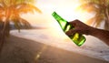 Hand catching a bottle of beer backlit on tropical beach Royalty Free Stock Photo