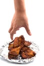Hand catching roasted wing. delicious grill chicken on foil on i
