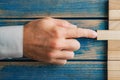 Hand of caucasian businessman pushing a wooden peg into a stack of them Royalty Free Stock Photo