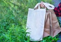 Hand of caucasian girl holding eco friendly white cloth (canvas fabric) bag and paper bags for organic shopping. Royalty Free Stock Photo