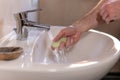 Hand of caucasian man holding antibacterial soap under running water tap. Washing hands, personal hygiene, hand sanitizing Royalty Free Stock Photo