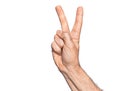 Hand of caucasian middle age man over isolated white background counting number 2 showing two fingers, gesturing victory and Royalty Free Stock Photo