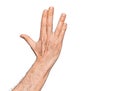 Hand of caucasian middle age man over isolated white background greeting doing Vulcan salute, showing back of the hand and Royalty Free Stock Photo