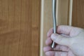 The hand of a Caucasian middle-aged man is holding the metal handle of a cabinet Royalty Free Stock Photo