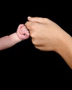 The hand of a caucasian newborn with a clenched fist bumps the knuckles against the mother`s fist. Royalty Free Stock Photo