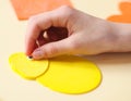 The hand of a caucasian teenage girl glues a decorative eye on a felt yellow chick Royalty Free Stock Photo