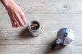 Hand of caucasian woman adding ground coffee to italian moka pot. Royalty Free Stock Photo