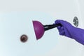 The hand of a caucasian woman cleans the blockage in bathroom with a plunger. Hair in the bathtub drain Royalty Free Stock Photo