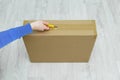 The hand of a caucasian woman opens cardboard box with a clerical knife