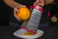 Chef rubs orange peel close-up in the kitchen Royalty Free Stock Photo
