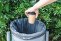 Hand of a caucasian woman trashing a cup of  coffee in a bin Royalty Free Stock Photo