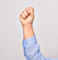 Hand of caucasian young activist woman doing protest sign with closed fist raised up over isolated white background Royalty Free Stock Photo