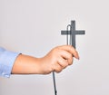 Hand of caucasian young catholic woman holding christian cross over isolated white background Royalty Free Stock Photo