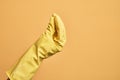 Hand of caucasian young man with cleaning glove over isolated yellow background doing Italian gesture with fingers together, Royalty Free Stock Photo
