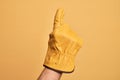 Hand of caucasian young man with gardener glove over isolated yellow background counting number one using index finger, showing Royalty Free Stock Photo