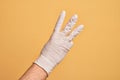 Hand of caucasian young man with medical glove over isolated yellow background counting number 3 showing three fingers Royalty Free Stock Photo