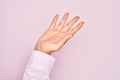 Hand of caucasian young man showing fingers over isolated pink background presenting with open palm, reaching for support and Royalty Free Stock Photo