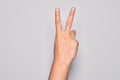 Hand of caucasian young man showing fingers over isolated white background counting number 2 showing two fingers, gesturing Royalty Free Stock Photo