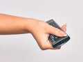 Hand of caucasian young woman changing television channel holding tv remote control over isolated white background Royalty Free Stock Photo