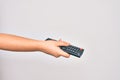 Hand of caucasian young woman changing television channel holding tv remote control over isolated white background Royalty Free Stock Photo