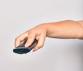 Hand of caucasian young woman changing television channel holding tv remote control over isolated white background Royalty Free Stock Photo