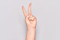 Hand of caucasian young woman counting number 2 showing two fingers, gesturing victory and winner symbol Royalty Free Stock Photo