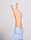 Hand of caucasian young woman doing victory symbol showing number two with streched fingers raised up over isolated white Royalty Free Stock Photo