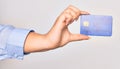 Hand of caucasian young woman holding credit card over isolated white background Royalty Free Stock Photo