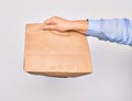 Hand of caucasian young woman holding deliver paper bag of takeaway food over isolated white background Royalty Free Stock Photo