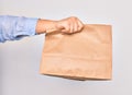 Hand of caucasian young woman holding deliver paper bag of takeaway food over isolated white background Royalty Free Stock Photo