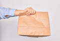 Hand of caucasian young woman holding deliver paper bag of takeaway food over isolated white background Royalty Free Stock Photo