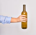 Hand of caucasian young woman holding empty glass botlle of wine over isolated white background Royalty Free Stock Photo
