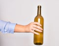 Hand of caucasian young woman holding empty glass botlle of wine over isolated white background Royalty Free Stock Photo