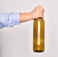 Hand of caucasian young woman holding empty glass botlle of wine over isolated white background Royalty Free Stock Photo