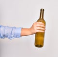 Hand of caucasian young woman holding empty glass botlle of wine over isolated white background Royalty Free Stock Photo