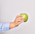 Hand of caucasian young woman holding green apple fruit over isolated white background Royalty Free Stock Photo