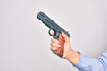 Hand of caucasian young woman holding gun over isolated white background Royalty Free Stock Photo