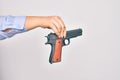 Hand of caucasian young woman holding gun over isolated white background Royalty Free Stock Photo