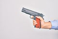 Hand of caucasian young woman holding gun over isolated white background Royalty Free Stock Photo