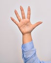 Hand of caucasian young woman showing number five with opened palm and streched fingers raised up over isolated white background Royalty Free Stock Photo
