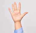 Hand of caucasian young woman showing number five with opened palm and streched fingers raised up over isolated white background Royalty Free Stock Photo