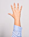 Hand of caucasian young woman showing number five with opened palm and streched fingers raised up over isolated white background Royalty Free Stock Photo