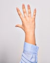 Hand of caucasian young woman showing number five with opened palm and streched fingers raised up over isolated white background Royalty Free Stock Photo