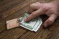 Hand caught in a mousetrap with one hundred dollars banknote.