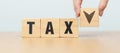 hand change wooden block with TAX text to UP and Down arrow icon. decrease and Increase, Taxpayer, Taxable Income, Tax Filing, Royalty Free Stock Photo