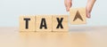 hand change wooden block with TAX text to UP and Down arrow icon. decrease and Increase, Taxpayer, Taxable Income, Tax Filing, Royalty Free Stock Photo