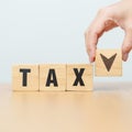hand change wooden block with TAX text to UP and Down arrow icon. decrease and Increase, Taxpayer, Taxable Income, Tax Filing, Royalty Free Stock Photo